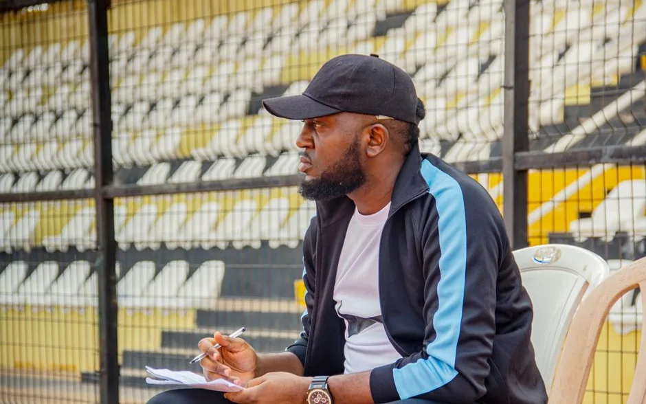 Entraîneur prenant des notes en observant un match depuis le bord d’un stade