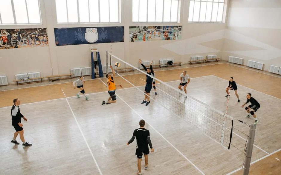 Salariés en tournoi de volley dans un gymnase, vu d’en haut